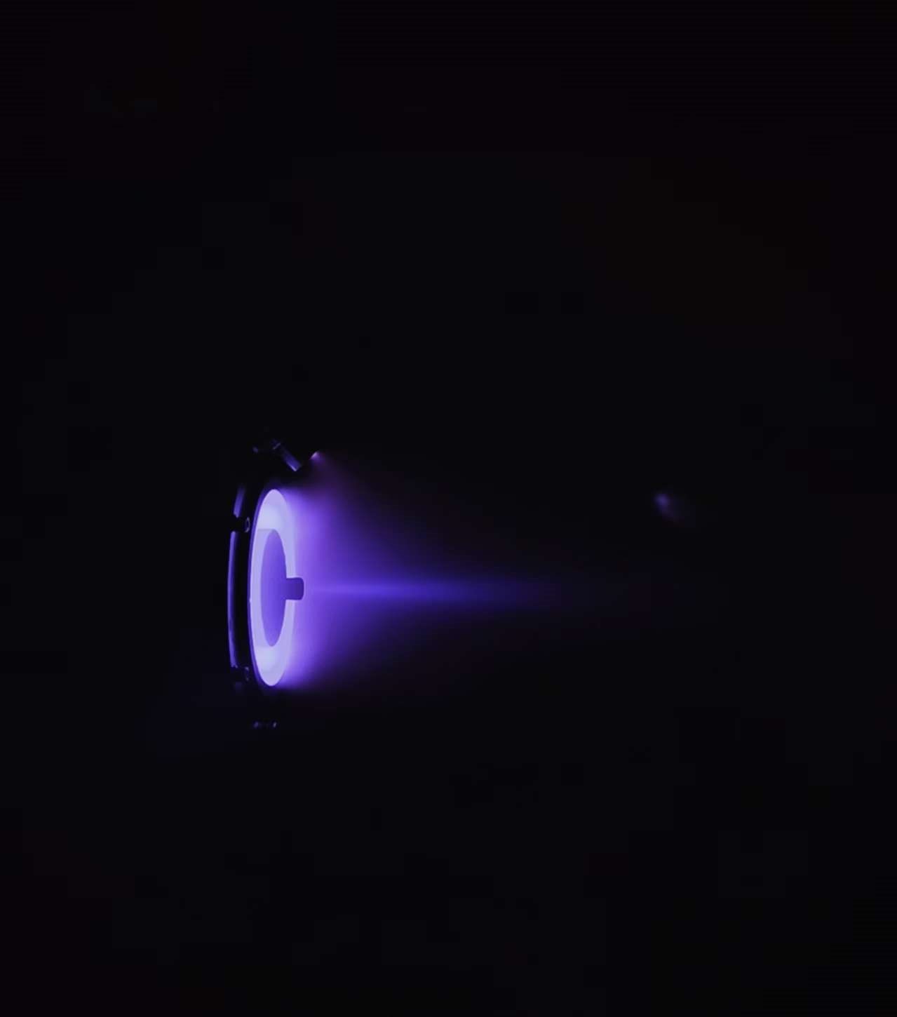 Close Hall thruster plasma plume glowing purple in vacuum test conditions